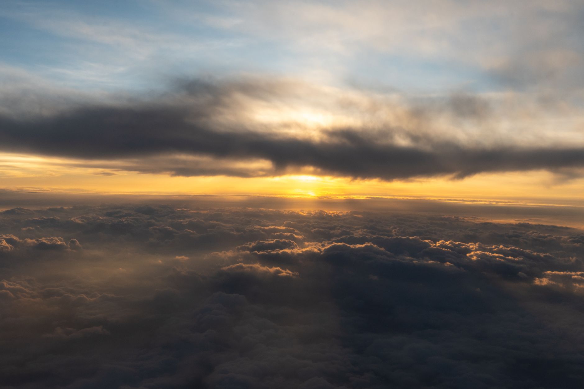 Sunrise light breaking through clouds over a quiet horizon